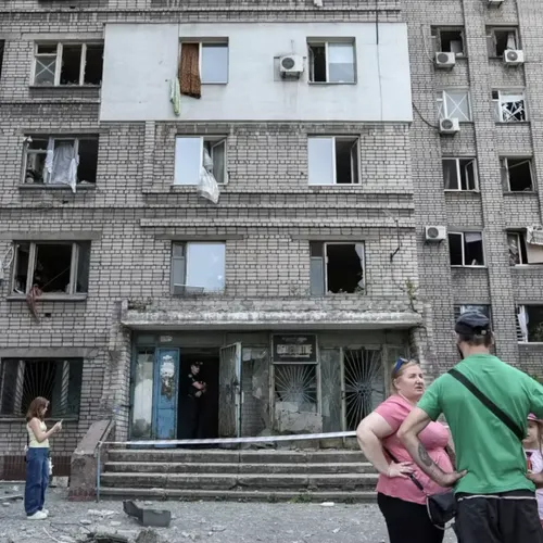 Residents stand near an apartment building that was damaged during a Russian missile strike